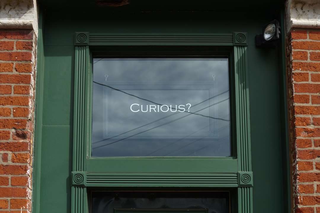 Framed glass window with the word “Curious?” displayed at Greenwoods Hotel, perfect for introducing frequently asked questions and encouraging discovery.