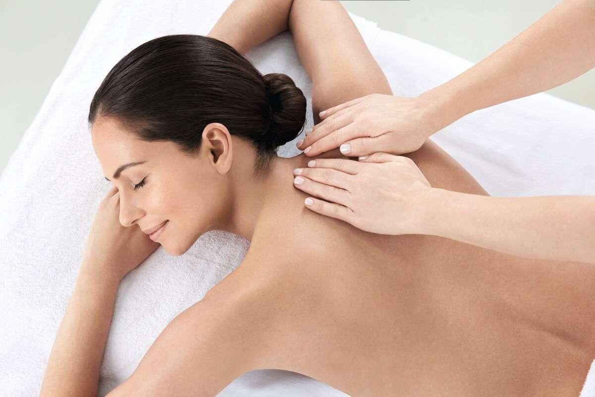 Spa therapist delivering a relaxing massage treatment at Greenwoods Hotel, perfect for beauty and wellness career listings.