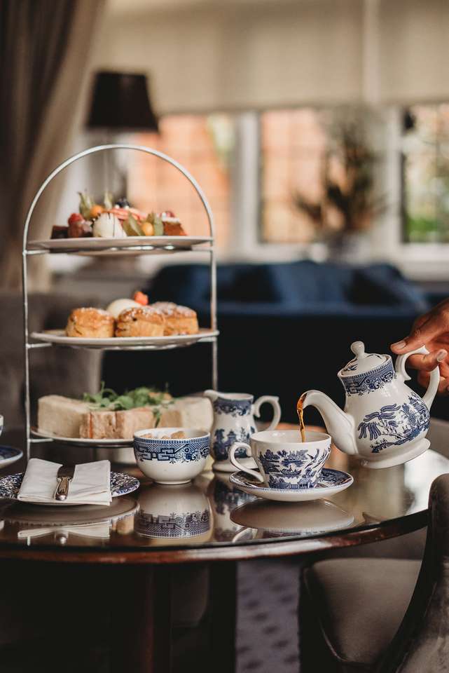 Elegant Baby Shower / Bridal Shower afternoon tea service at Greenwoods Hotel with blue patterned china, sandwiches and desserts on a three-tier stand.