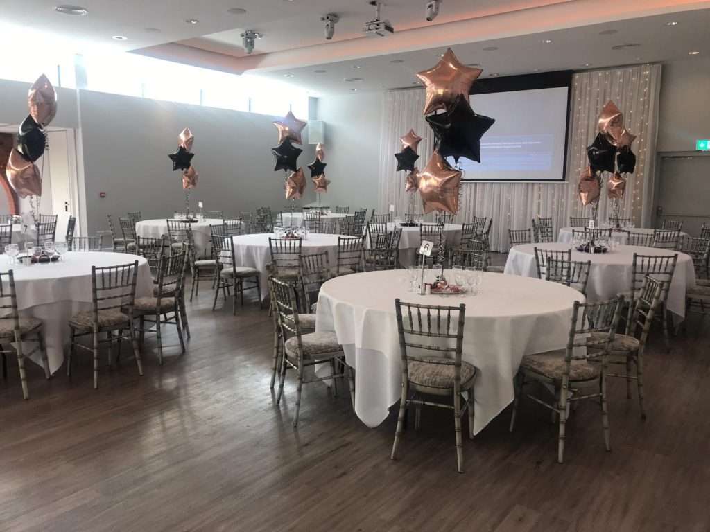 Charity ball event setup in the Garden Suite at Greenwoods Hotel, with elegant round tables and star balloons.