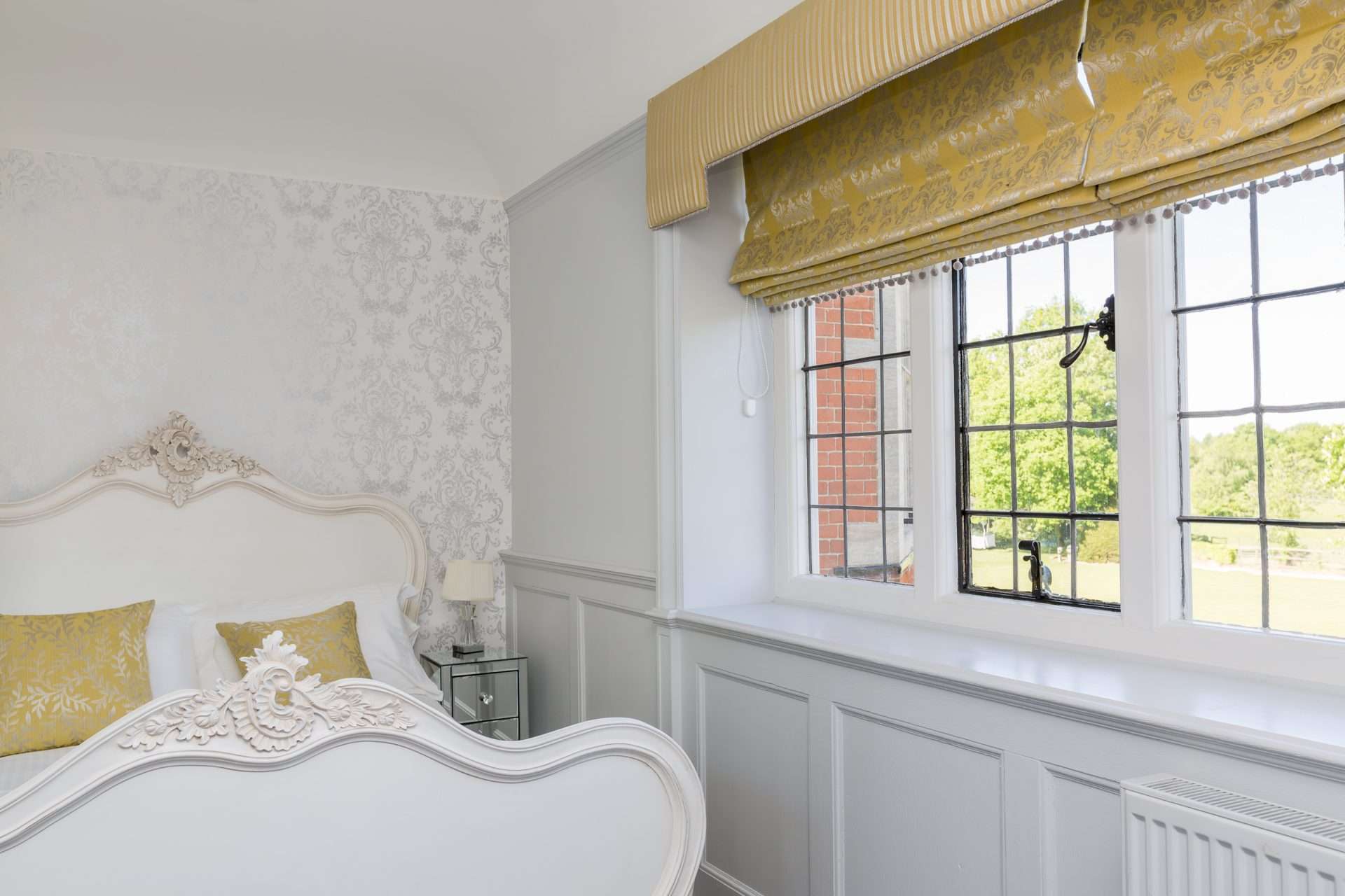 Classic hotel room with yellow accents and elegant furnishings at Greenwoods Hotel