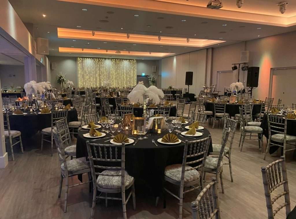 Charity gala event hosted in the Garden Suite at Greenwoods Hotel with white feathers and gold-themed tables.