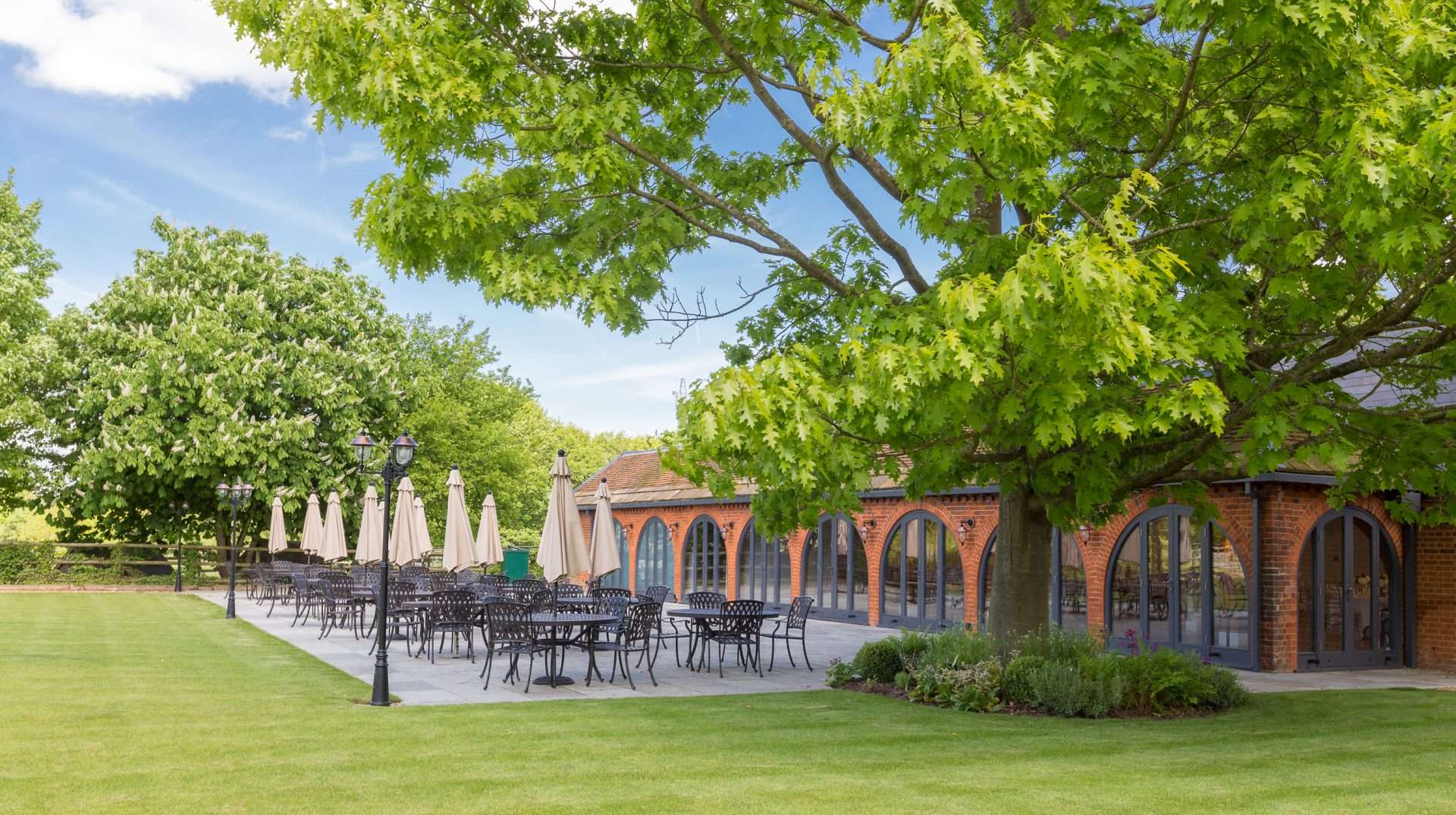Garden Suite Outdoor Terrace Greenwoods Hotel Spacious outdoor terrace of the Garden Suite at Greenwoods Hotel with patio seating under leafy trees.