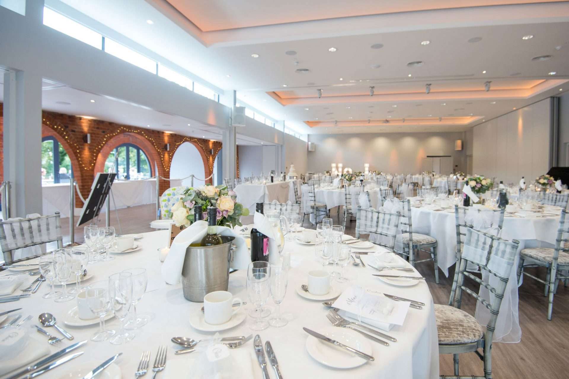 Wedding reception layout in the Garden Suite at Greenwoods Hotel with round tables, chairs, and floral centrepieces