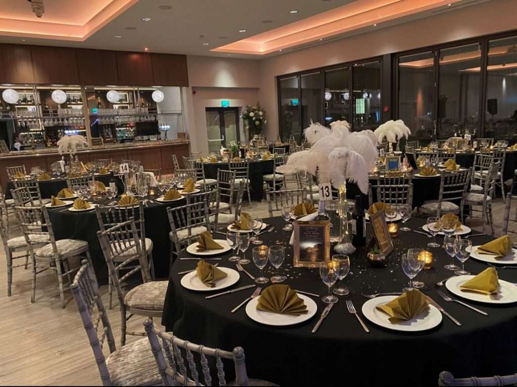 Black and gold table setup for a Gatsby-themed charity event in the Garden Suite with vintage-style décor.