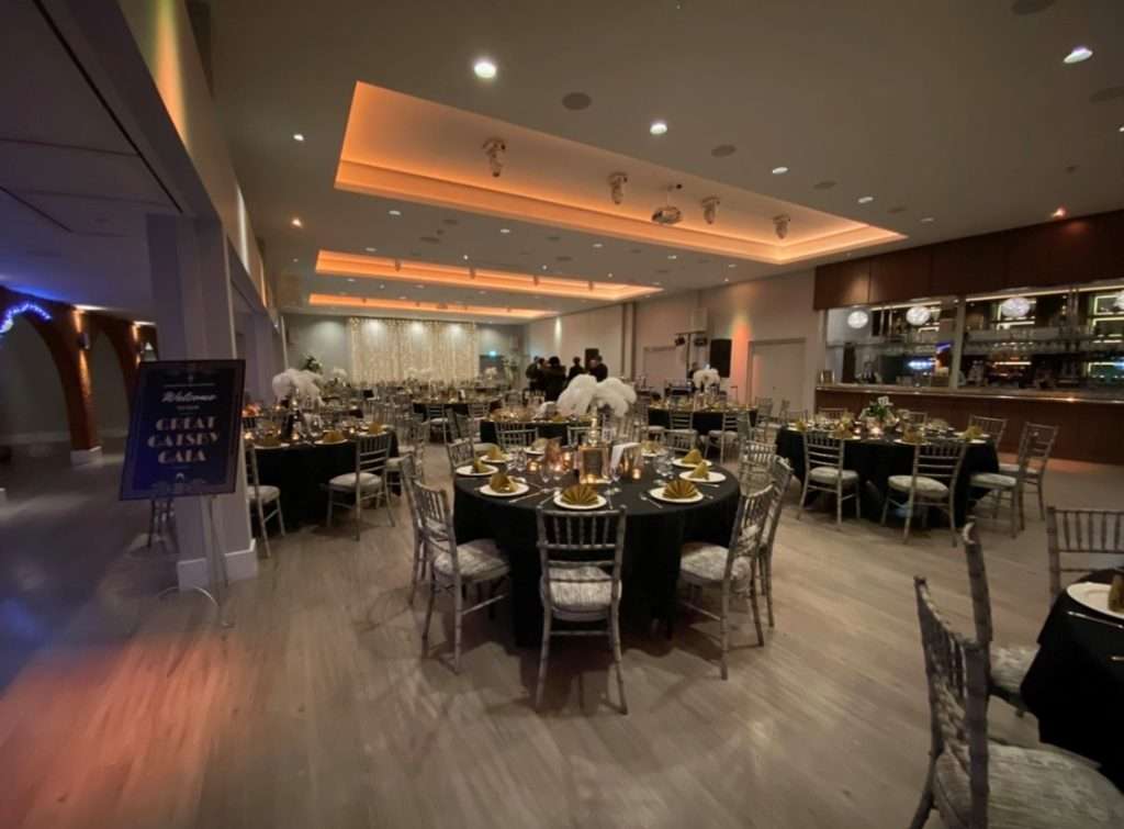 Great Gatsby themed charity gala setup in the Garden Suite at Greenwoods Hotel with feathered centrepieces and gold napkins.