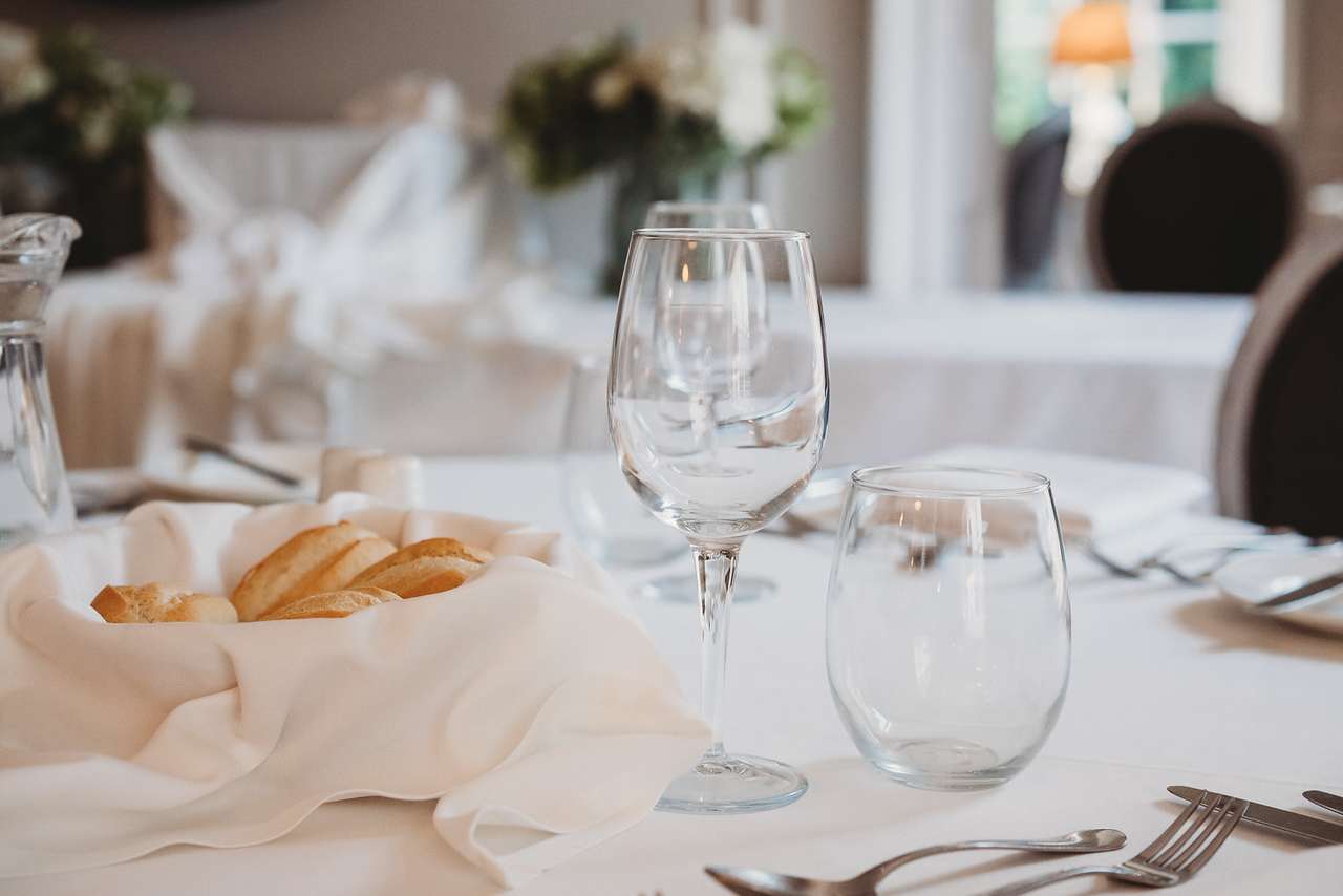 Fresh bread basket and wine glasses on a dining table at Greenwoods