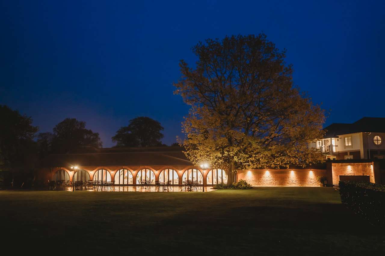 Courtyard view of Greenwoods Hotel illuminated at night