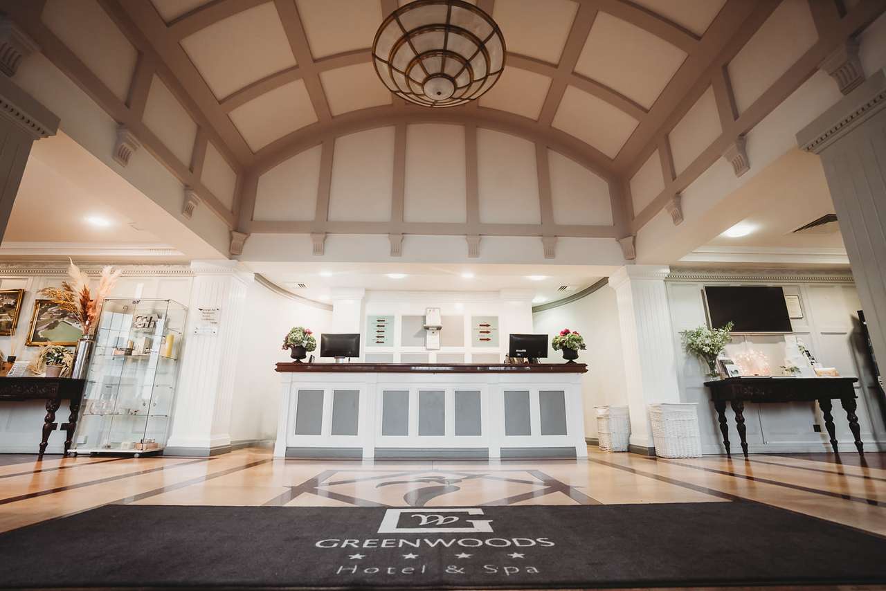 Reception area at Greenwoods Hotel & Spa with branded welcome mat and vaulted ceiling