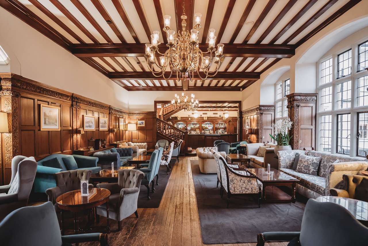 Full view of the lounge bar and seating area at Greenwoods Hotel with chandeliers and wooden interiors