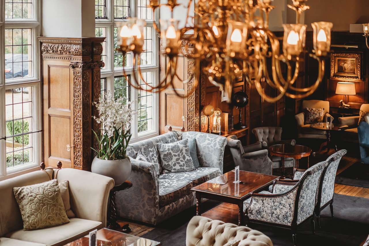 Close-up of the floral-patterned sofa in the lounge at Greenwoods Hotel with carved wood panels and lighting