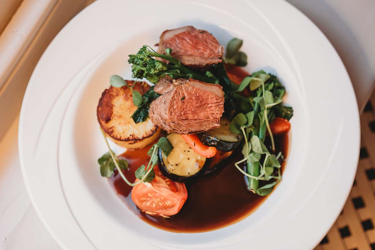 Roast lamb served with seasonal vegetables and rich gravy at Greenwoods