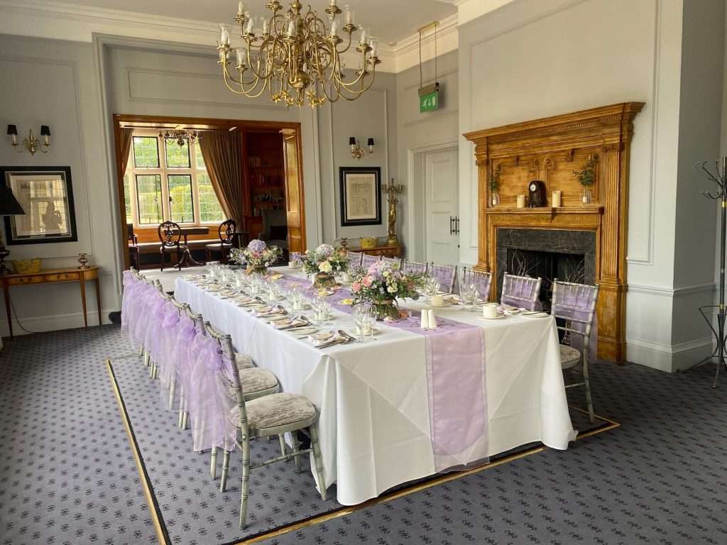 Elegant long table setup in the Library Room at Greenwoods Hotel with lavender chair sashes for a bridal or baby shower.