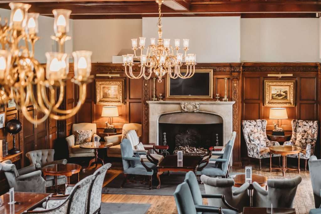 The fireplace seating area at Greenwoods Hotel Lounge Bar in Essex, offering a warm and luxurious setting for drinks or coffee.