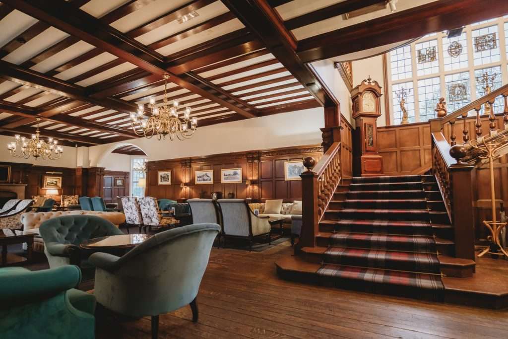 Interior of Greenwoods Hotel Lounge Bar featuring a grand staircase and elegant seating, perfect for drinks and social gatherings in Essex.