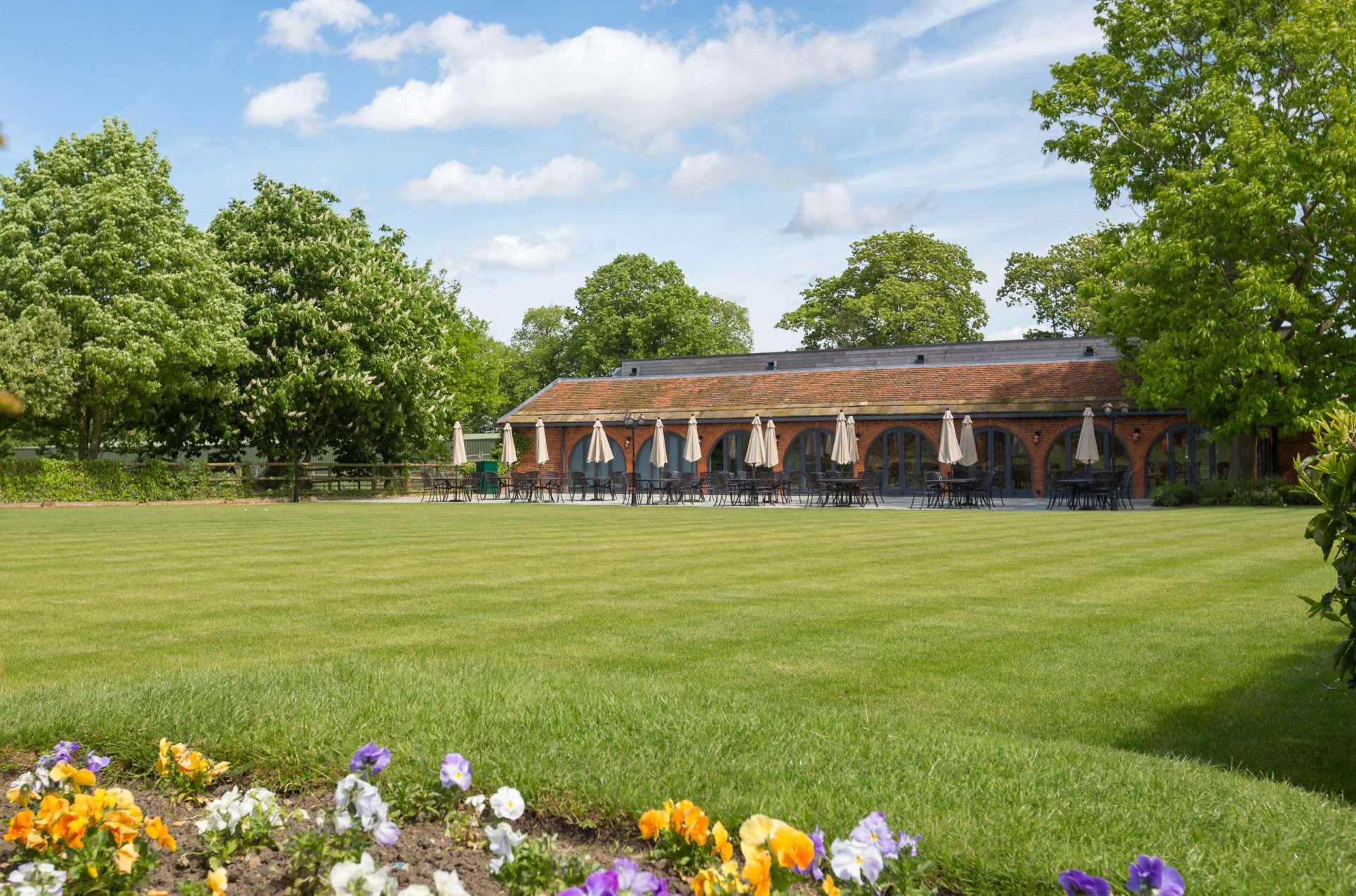 Outdoor patio behind the Garden Suite at Greenwoods Hotel with parasol-covered tables