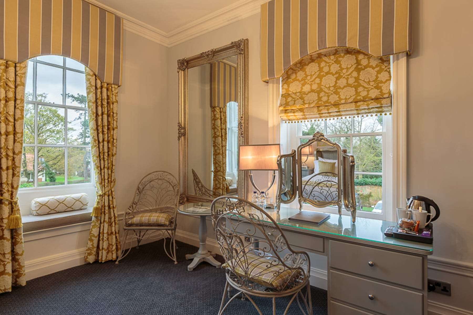 Vanity area in a premier hotel room at Greenwoods with elegant yellow styling