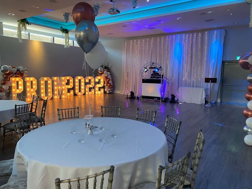 Illuminated Prom 2022 sign and DJ booth setup in the Garden Suite for a school prom celebration.