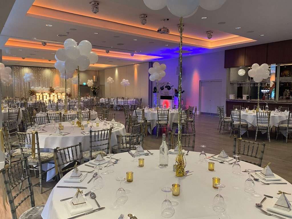 Final setup for school prom event at Greenwoods Hotel Garden Suite with white linens and gold accents.