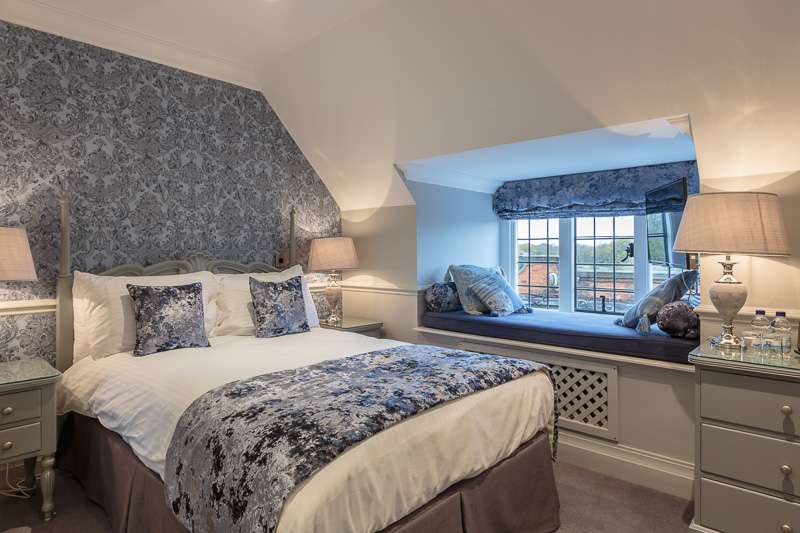Traditional room at Greenwoods Hotel featuring ornate headboard and elegant styling