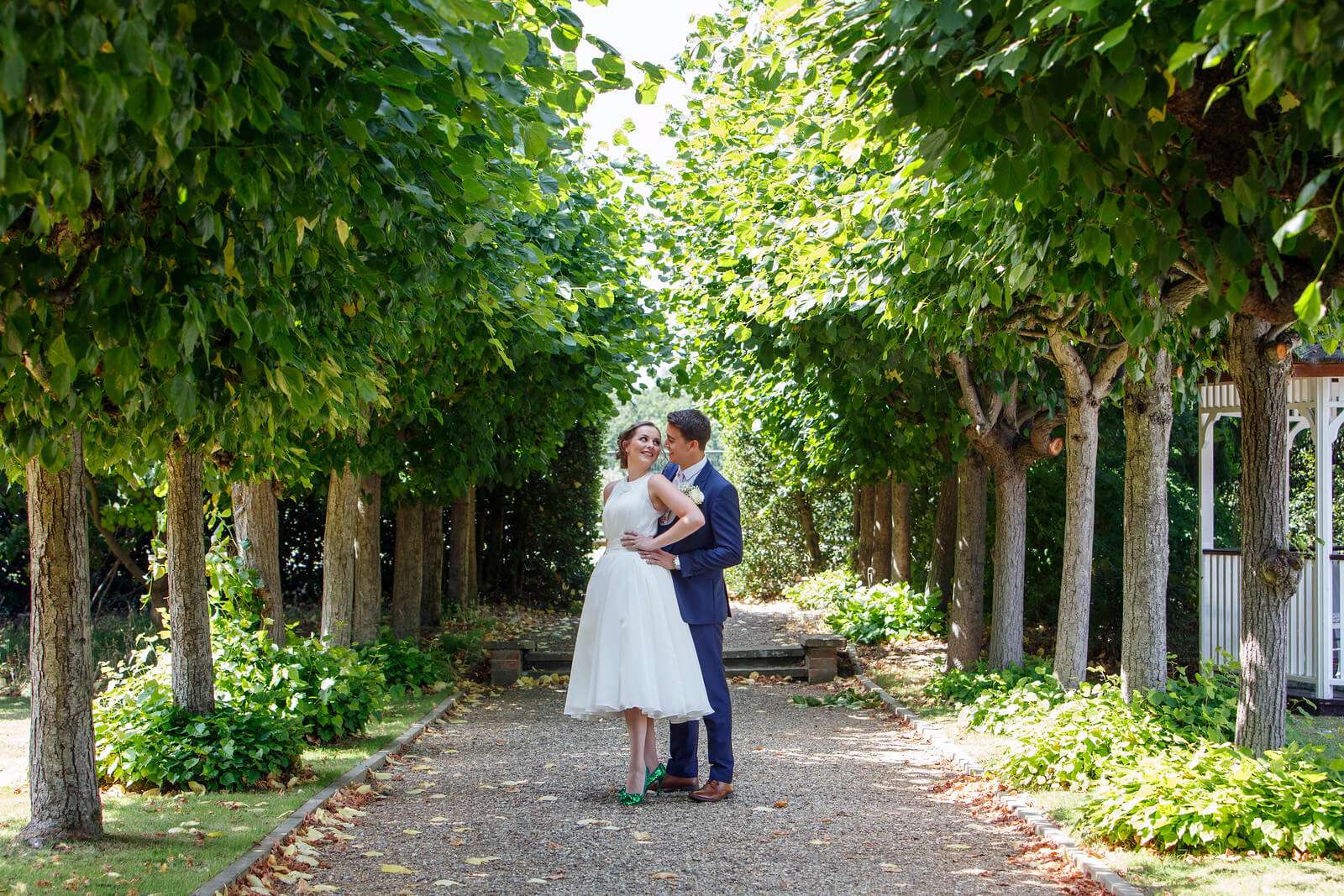 Bride and groom share a quiet moment near the garden gazebo at Greenwoods Hotel in Essex
