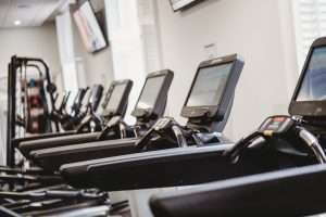 Row of modern cardio machines in the luxury gym at Greenwoods Hotel & Spa, featuring treadmills and fitness equipment in a bright, contemporary space