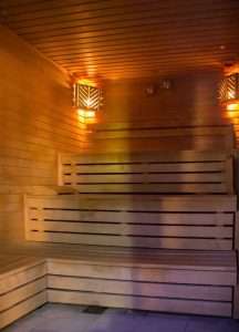 Interior of the luxury sauna at Greenwoods Hotel & Spa featuring warm wooden seating and ambient lighting for relaxation