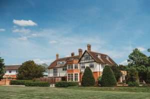 Exterior view of the manor house and lawns at Greenwoods Hotel and Spa, an Essex wedding venue.