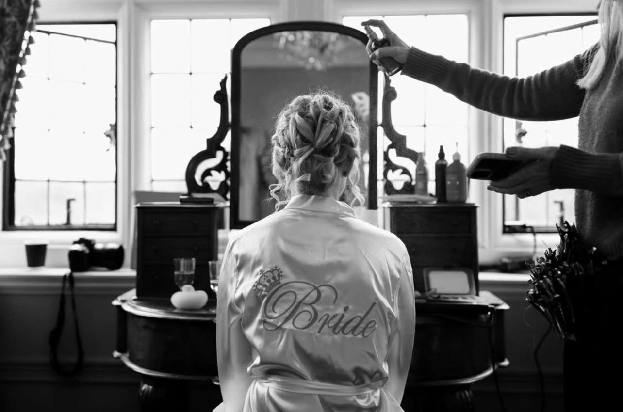 Bride having her hair styled in a dressing room at Greenwoods Hotel and Spa before her Essex wedding ceremony.