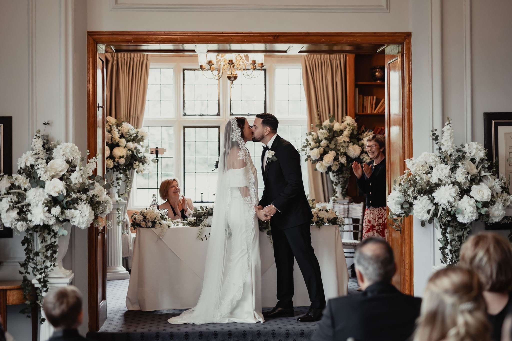 Bride and groom kissing during an indoor wedding ceremony in the manor house at Greenwoods Hotel and Spa.