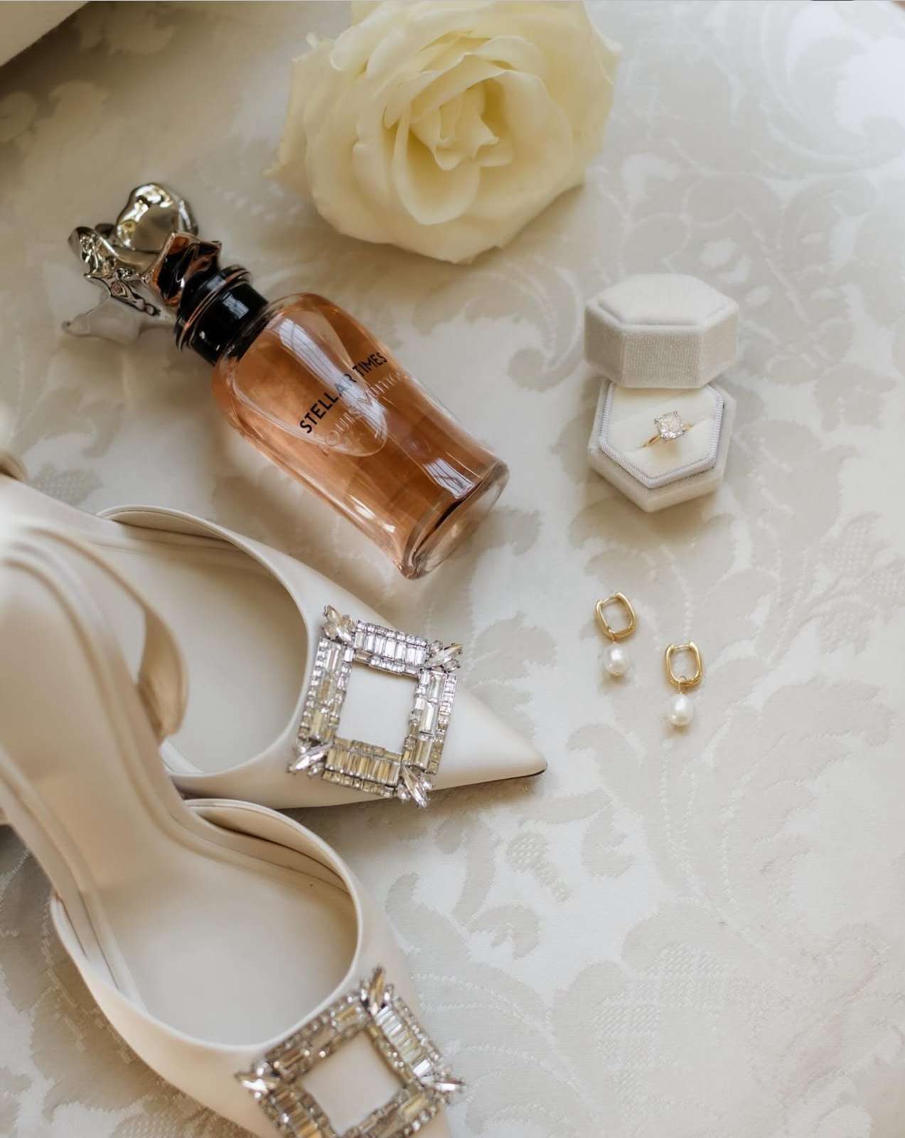 Bridal wedding details including shoes, perfume, earrings and engagement ring arranged before a dry hire wedding at Greenwoods Hotel and Spa.