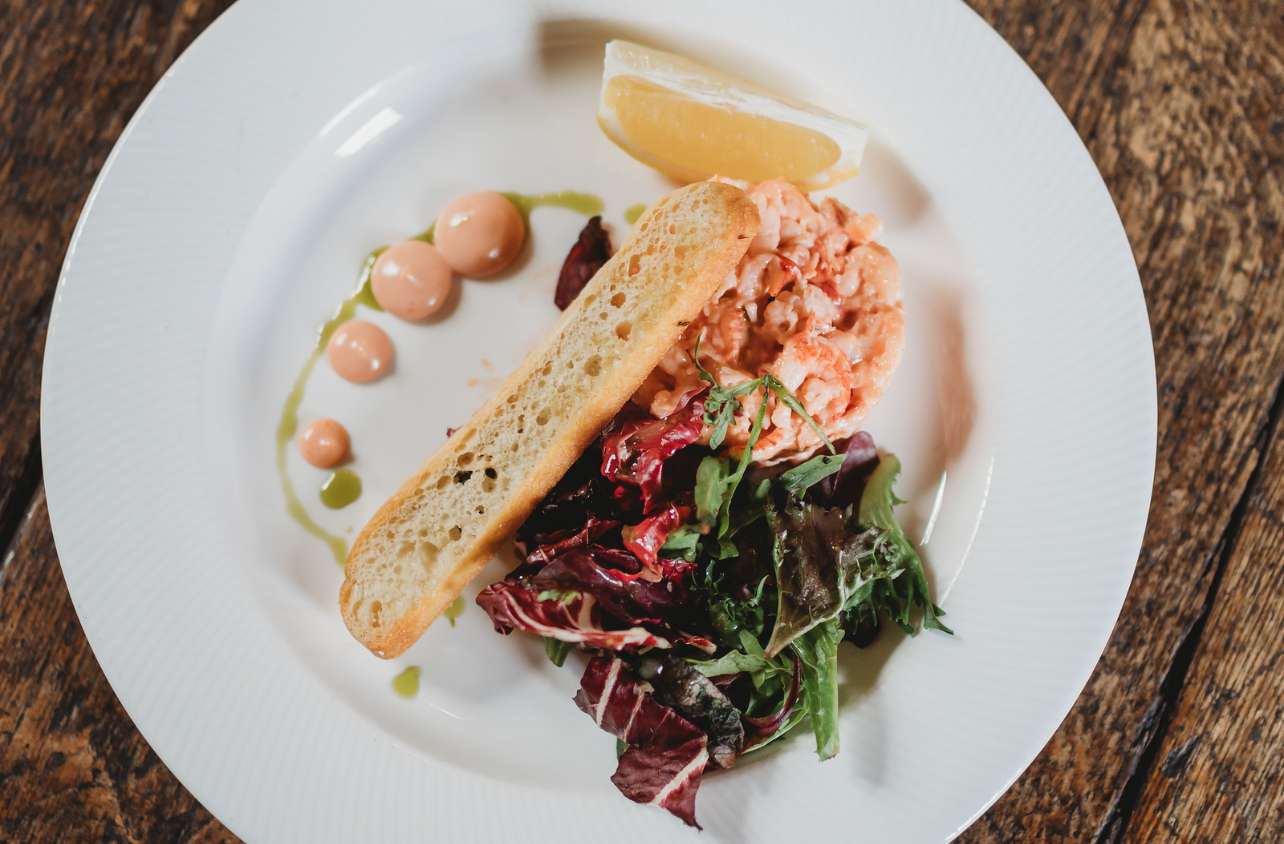 Plated seafood starter with salad and toast, served as part of a catered wedding menu at Greenwoods Hotel and Spa.
