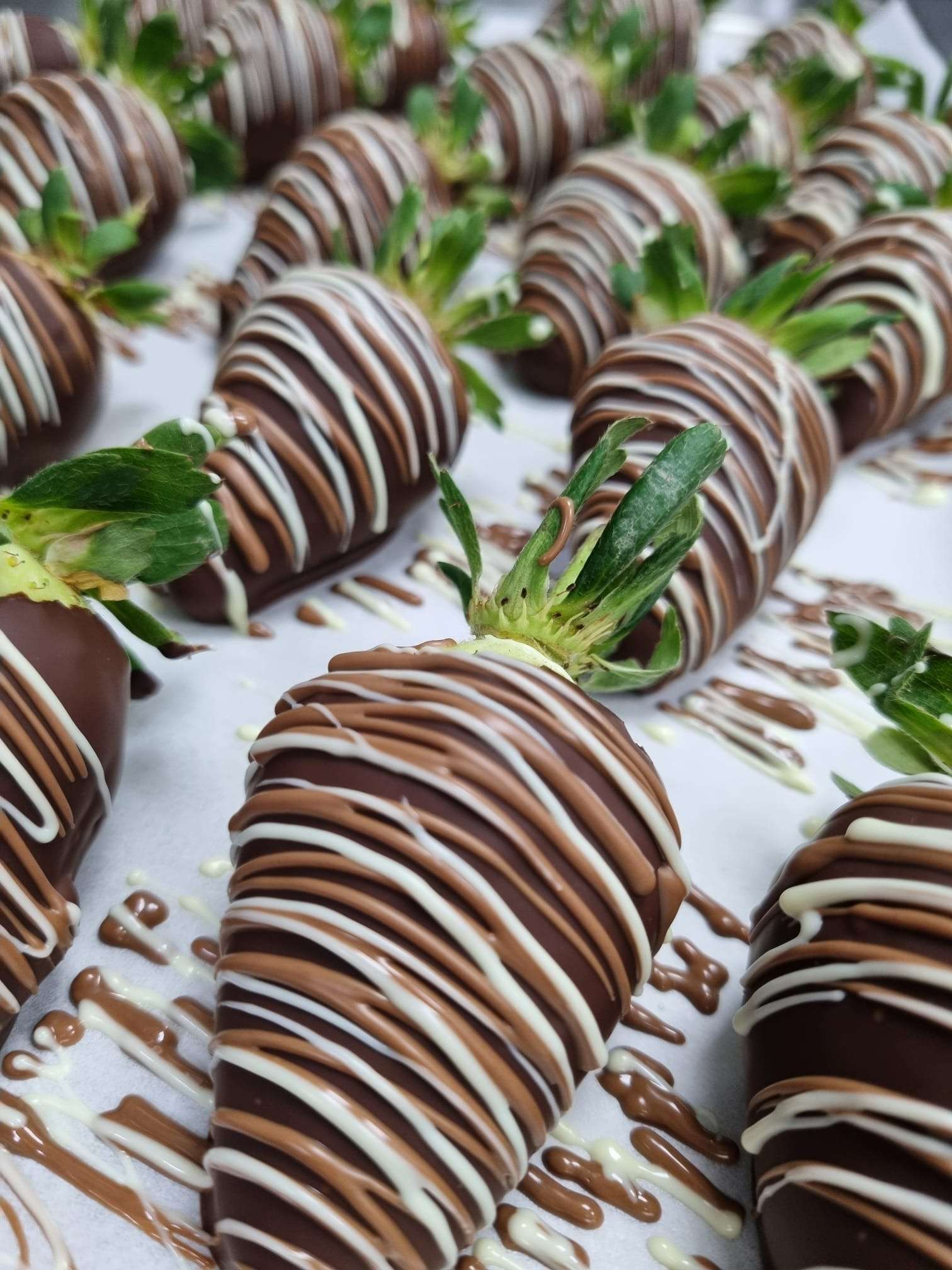 Chocolate covered strawberries with white and milk chocolate drizzle prepared for wedding catering at Greenwoods Hotel and Spa.