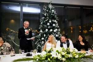 Wedding speech during a festive catered wedding reception with Christmas tree decor at Greenwoods Hotel and Spa.