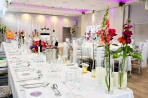 Colourful wedding breakfast table styling with flowers, glassware and dining setup at Greenwoods Hotel and Spa.