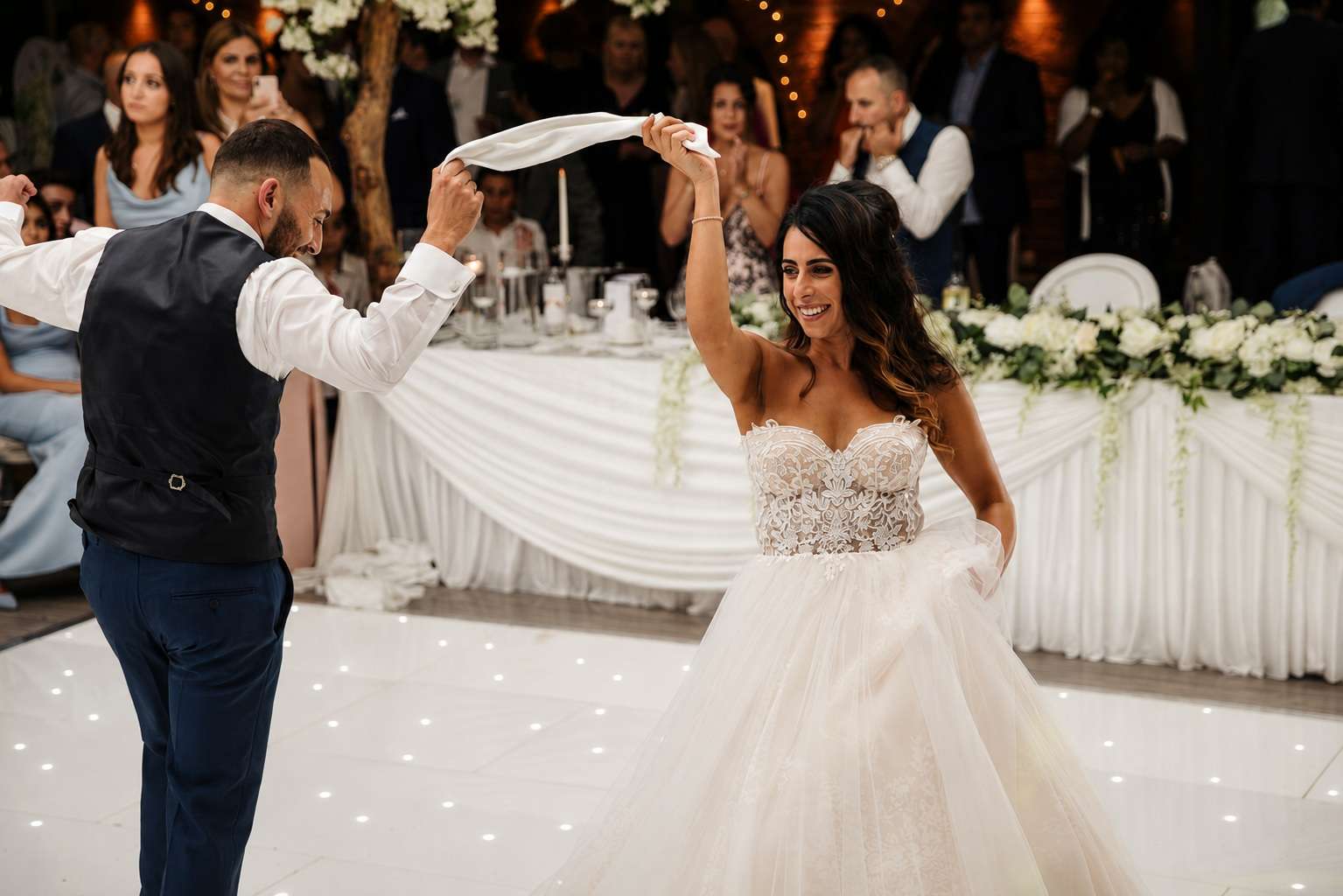 Bride and groom enjoying their first dance on a white dance floor during a dry hire wedding reception at Greenwoods Hotel and Spa.