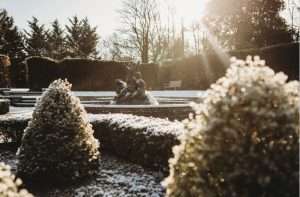 Frost-covered gardens and fountain at Greenwoods Hotel & Spa, creating a romantic setting for winter weddings in Essex.