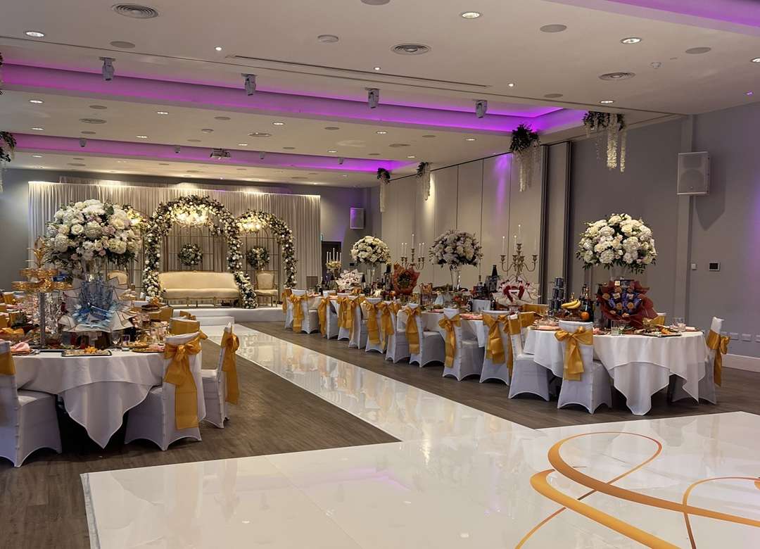 Cultural wedding reception setup with floral decor and illuminated dance floor at Greenwoods Hotel & Spa in Essex.