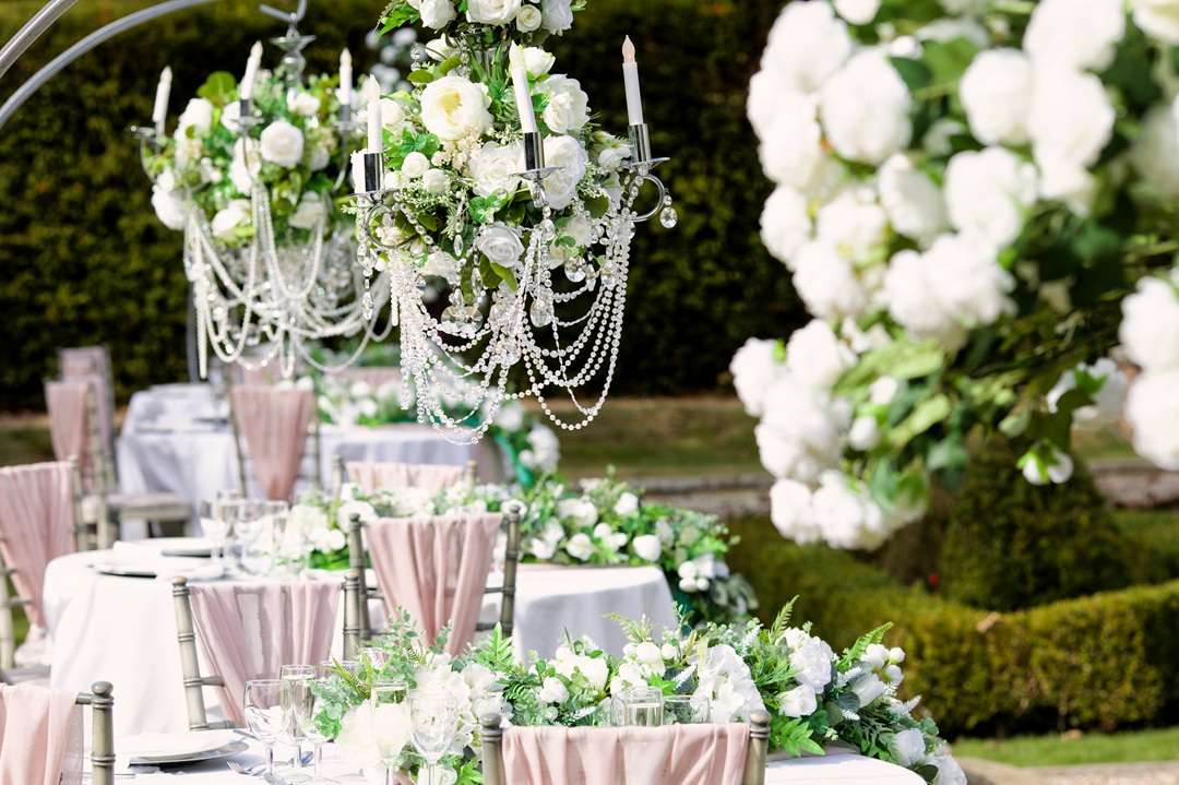 Outdoor dry hire wedding table decor with white flowers and crystal chandeliers at Greenwoods Hotel & Spa in Essex.