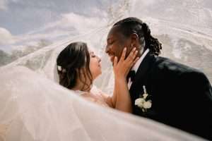 Bride and groom sharing a close romantic portrait beneath the bridal veil at Greenwoods Hotel and Spa.