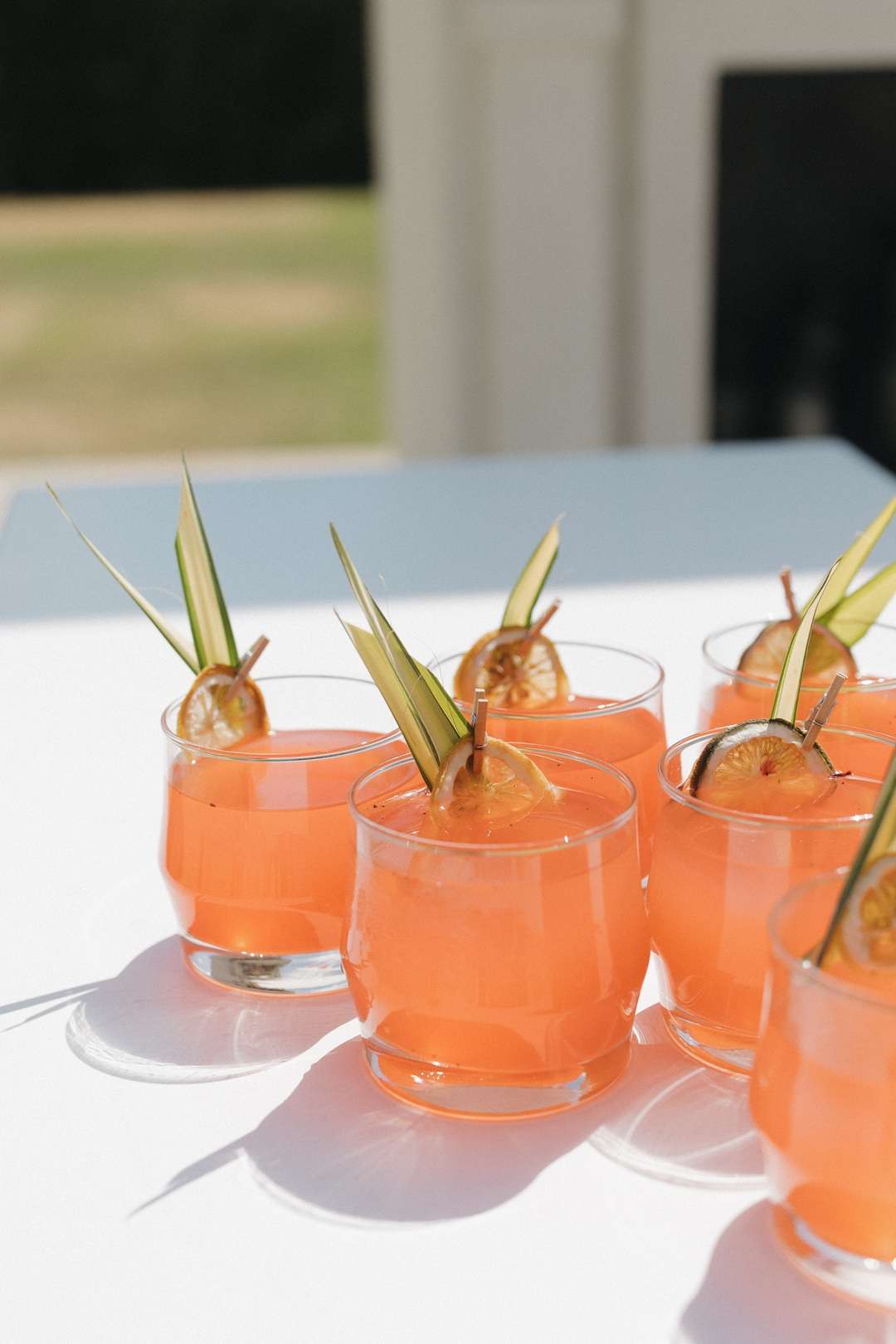 Peach coloured wedding reception drinks arranged for guests at an outdoor celebration.
